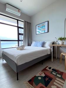 亞庇的住宿－Jesselton Quay by Bunga Raya Homes，一间卧室配有一张带书桌的床和窗户。