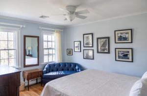 a bedroom with a blue bed and a blue couch at Rams Head Inn in Shelter Island