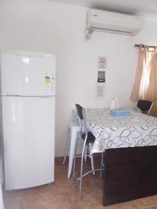 a kitchen with a table and chairs and a refrigerator at DEPARTAMENTO AVELLANEDA 3 5 3 4 2 3 6 2 6 3 con GARAJE PRIVADO perfecto para hacer noche y continuar viaje in Villa María