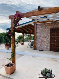 a wooden pergola with a potted plant on a patio at Chalet in campagna in Partanna