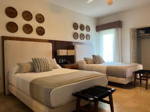 a bedroom with two beds and clocks on the wall at Beachfront 2 bedroom Condo in Playa Royale Resort, Nuevo Vallarta in Nuevo Vallarta  +120 photos