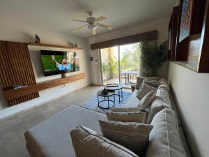 uma sala de estar com um sofá e uma televisão de ecrã plano em Beachfront 2 bedroom Condo in Playa Royale Resort, Nuevo Vallarta em Nuevo Vallarta 