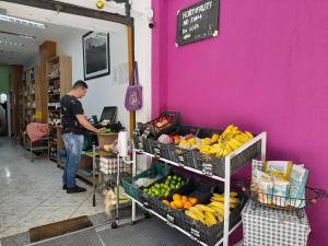 un hombre parado en una tienda con frutas y verduras en Glória' loft, en Río de Janeiro