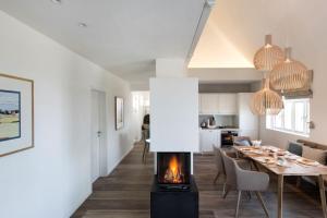 a living room and dining room with a fireplace at Reetdorf Geltinger Birk Künstlerkate Sandkoppel in Nieby +12 photos
