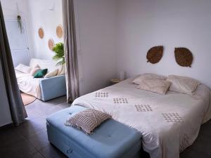 a bedroom with a large bed and a blue ottoman at T2 Paisible et spacieux in Baie-Mahault
