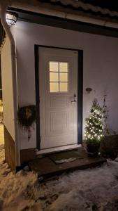 a white door with a christmas tree next to it at Skogro ved Norefjell in Noresund