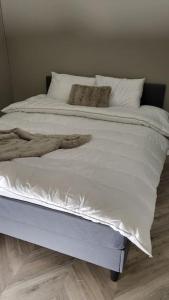 uma grande cama branca com lençóis e almofadas brancos em Skogro ved Norefjell em Noresund