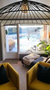 - un salon avec deux chaises et une grande fenêtre dans l'établissement Skogro ved Norefjell, à Noresund