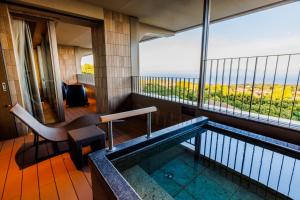 a hotel room with a swimming pool and a balcony at KAMENOI HOTEL Izukogen in Ito