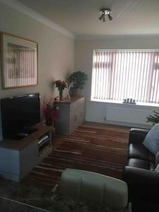 a living room with a television and a couch at 1 bedroom apartment with parking. in Great Wakering