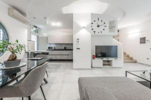ein Wohnzimmer mit einem Tisch und einer Uhr an der Wand in der Unterkunft Villa con giardino in piena città in Modena