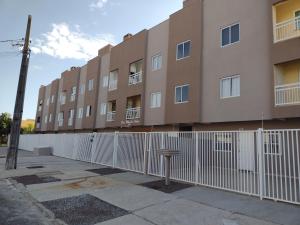 a building with a white fence next to a building at APARTAMENTO COQUEIROS A 1 QUADRA DO MAR in Guaratuba