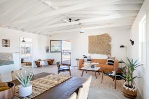 uma sala de estar com um sofá e uma mesa em Remote, Hot Tub, Cowboy Pool, Hammocks em Sunfair Heights