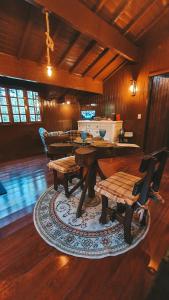 a living room with a wooden table and chairs at Cabana Retrô com lareira e Ofurô em Monte Verde in Monte Verde