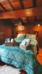 Una cama con dos cestas encima. en Cabana Retrô - Forest Place, en Monte Verde