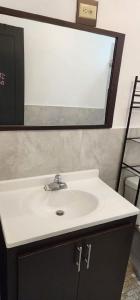 y baño con lavabo blanco y espejo. en Villa near Crash Boat Beach Aguadilla, PR 2nd flr, en Camaceyes