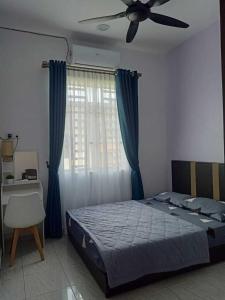 a bedroom with a bed and a ceiling fan at Homestay Pinang Tunggal in Sungai Petani
