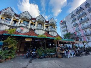 a building with tables and chairs in front of it at Andaman Place Guesthouse in Patong Beach