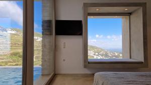 una camera da letto con una grande finestra con vista di Ivy's Natural Resort ad Arnádhos