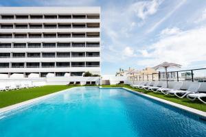 ケアンズにあるThe Benson Hotelの建物の前のプール