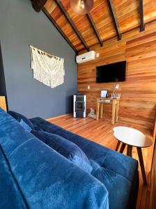 sala de estar con sofá azul y mesa en lacascatachales Chale Aspen, en Urubici