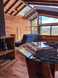 una camera con divano e tavolo in una casa di lacascatachales Chale Aspen a Urubici
