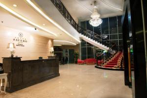 un vestíbulo con una escalera y sillas rojas en Grand Savero Hotel Bogor en Bogor