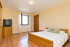 a bedroom with a large bed and a television at Villas Montrin in Kaštel
