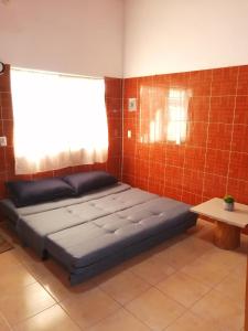 Cama en habitación con pared de ladrillo en Casa Maribel Lugar para descansar en ixtapa en Ixtapa