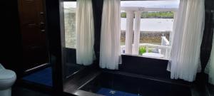 a bathroom with a window with a view of the beach at SujungSesang Dive Resort in Agus