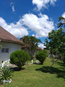 una casa con un patio con árboles y arbustos en SujungSesang Dive Resort, en Agus
