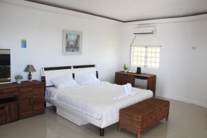 1 dormitorio con 1 cama blanca y TV en SujungSesang Dive Resort, en Agus