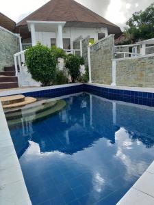 a blue tile swimming pool in front of a house at SujungSesang Dive Resort in Agus