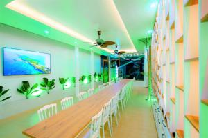 - une longue table dans une pièce avec des chaises blanches dans l'établissement HAPPY Villa Hue City, à Phú Vang