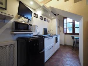 a kitchen with a black refrigerator and a tv on the wall at Nice apartment in Gambassi Terme with shared pool in Gambassi Terme