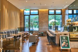 un restaurante con mesas, sillas y ventanas en The Fuli Resort Chihpen en Taitung