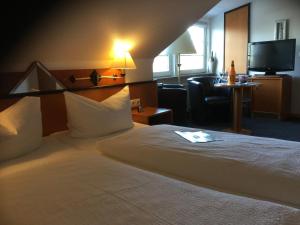 ein Hotelzimmer mit einem Bett und einem TV in der Unterkunft Meeresblick Ferienwohnung in Husum