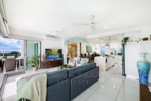 a living room with a couch and a kitchen at ZEN BY THE WATER - Darwin's Premier Ocean View Family Retreat in Darwin