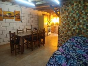 a kitchen and dining room with a table and chairs at Cabañas Rio y Playa in Atos Pampa