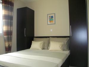 a bed with a black headboard and white pillows at Luna Apartments in Trogir