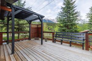 a wooden deck with a bench and a tree at The Qu INN - Cozy Cabin in Parson