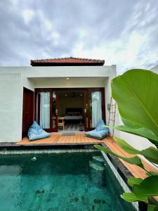 a villa with a swimming pool and a house at The Seaglass Villas Bingin in Uluwatu