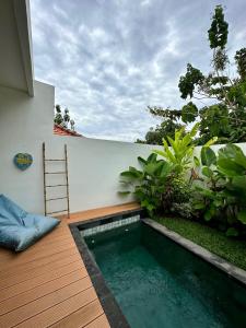una piccola piscina su una terrazza in legno con scala di The Seaglass Villas Bingin a Uluwatu