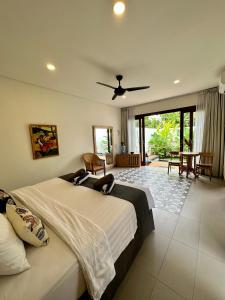 1 dormitorio con 1 cama grande y ventilador de techo en The Seaglass Villas Bingin en Uluwatu