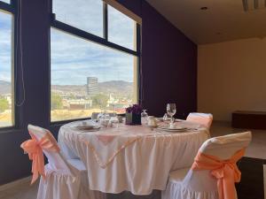 einen Tisch mit 2 Stühlen und einen Tisch mit einem Fenster in der Unterkunft Hotel del Valle Inn in Pachuca de Soto