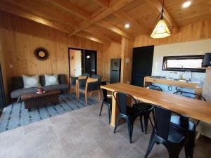 a living room with a table and a couch at Cabaña de campo in Vichuquén