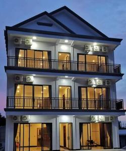 a large house with a lit up facade at Paradise Cozy Guesthouse Sihanoukville in Sihanoukville
