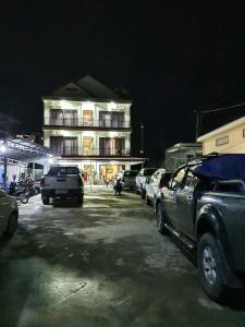 un parking avec des voitures garées devant un bâtiment dans l'établissement Paradise Cozy Guesthouse Sihanoukville, à Sihanoukville