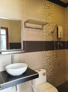 y baño con lavabo, aseo y espejo. en Paradise Cozy Guesthouse Sihanoukville, en Sihanoukville