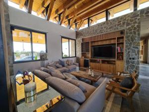 a living room with a large couch and a stone wall at Impresionante Residencia de lujo en Condominio Top in San Miguel de Allende